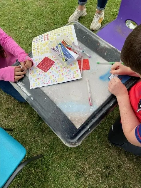 children choosing stickers to decorate their badges children choosing stickers to decorate their badges