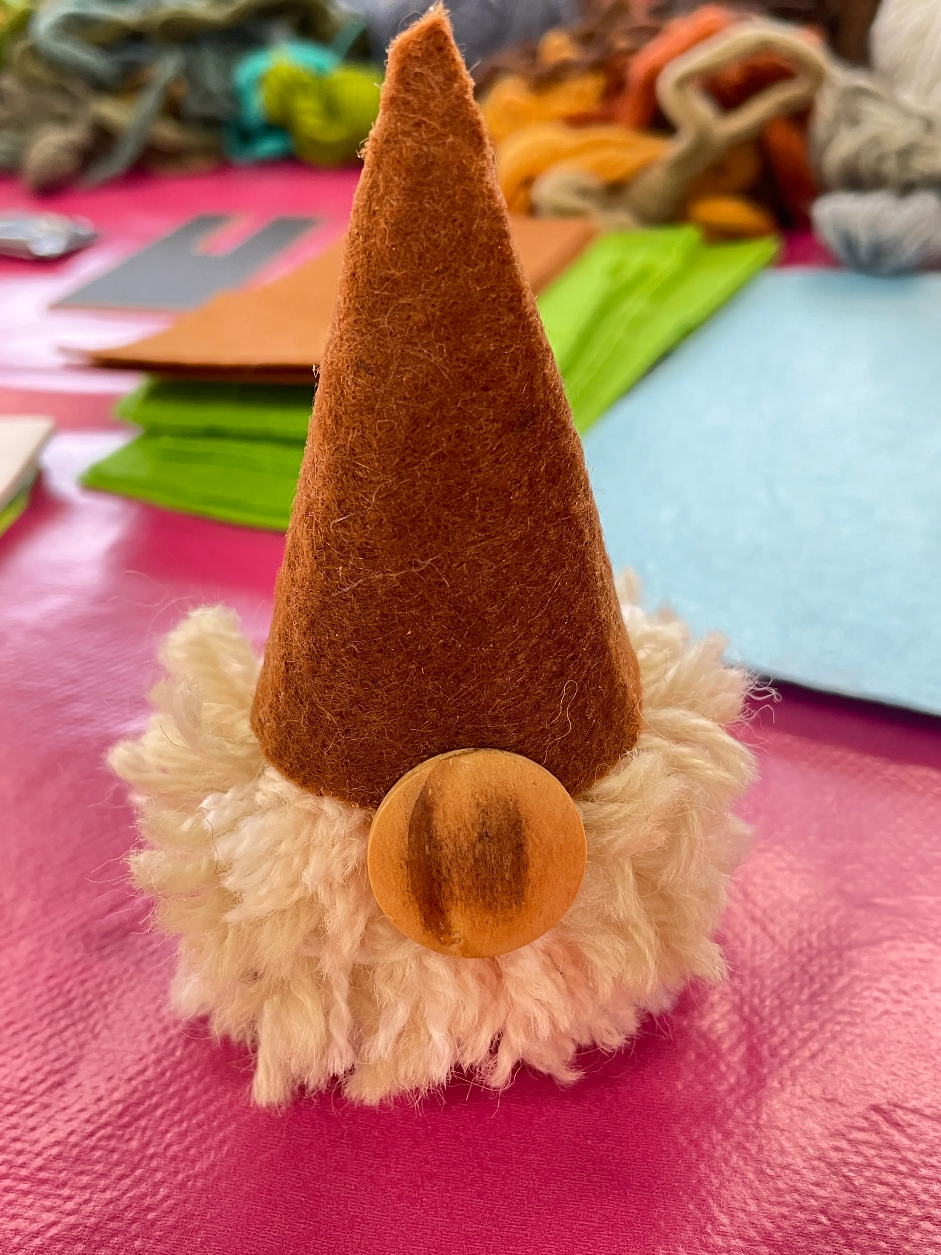 handmade gonk with a green felt hat sits on the table