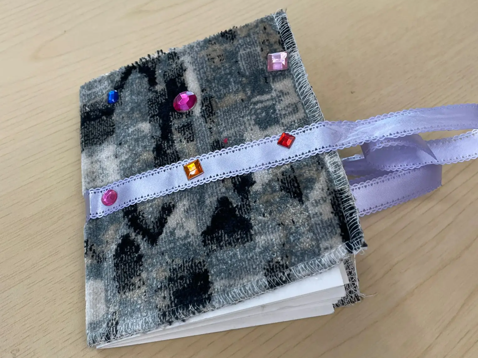 a fabric covered notebook decorated with adhesive gems
